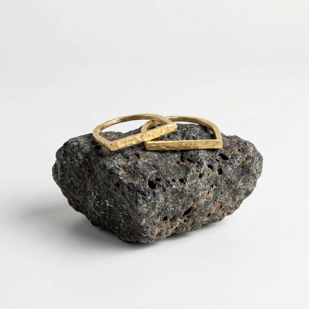 Brass ring on a textured black stone with a white background
