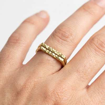 
                    
                      Brass ring on a finger against a white background
                    
                  