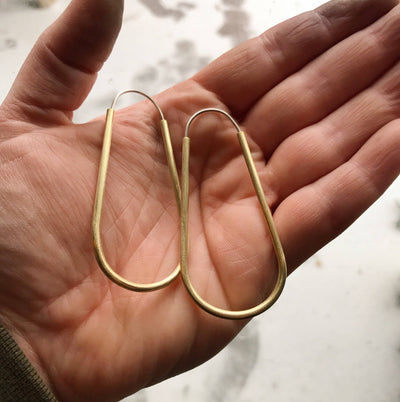 
                    
                      Long Hollow Hoops earrings, raw brass with silver stainless steel posts, pair held in hand for scale.
                    
                  