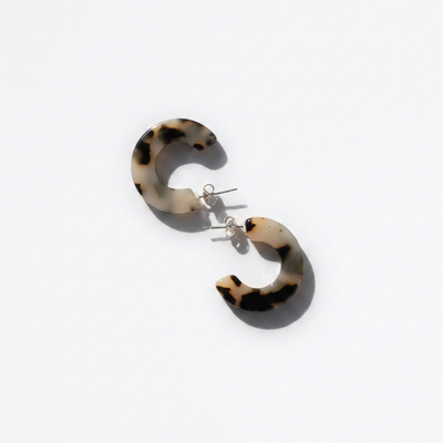 
                    
                      NAT + NOOR Ray hoop earrings, Ivory Tortoise acetate, flat lay pair on white, showing silver stainless steel posts.
                    
                  