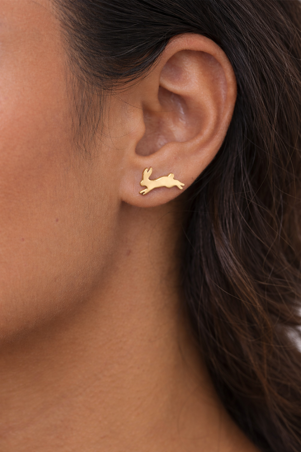 Fortune Bunny Studs, 18K gold-plated brass stud earrings, close-up on right earlobe.