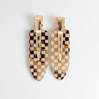 
                    
                      Peignee Paris Checkerboard Hair Clips, set of two, brown, tan, white cellulose acetate with gold clips, flat lay on white.
                    
                  