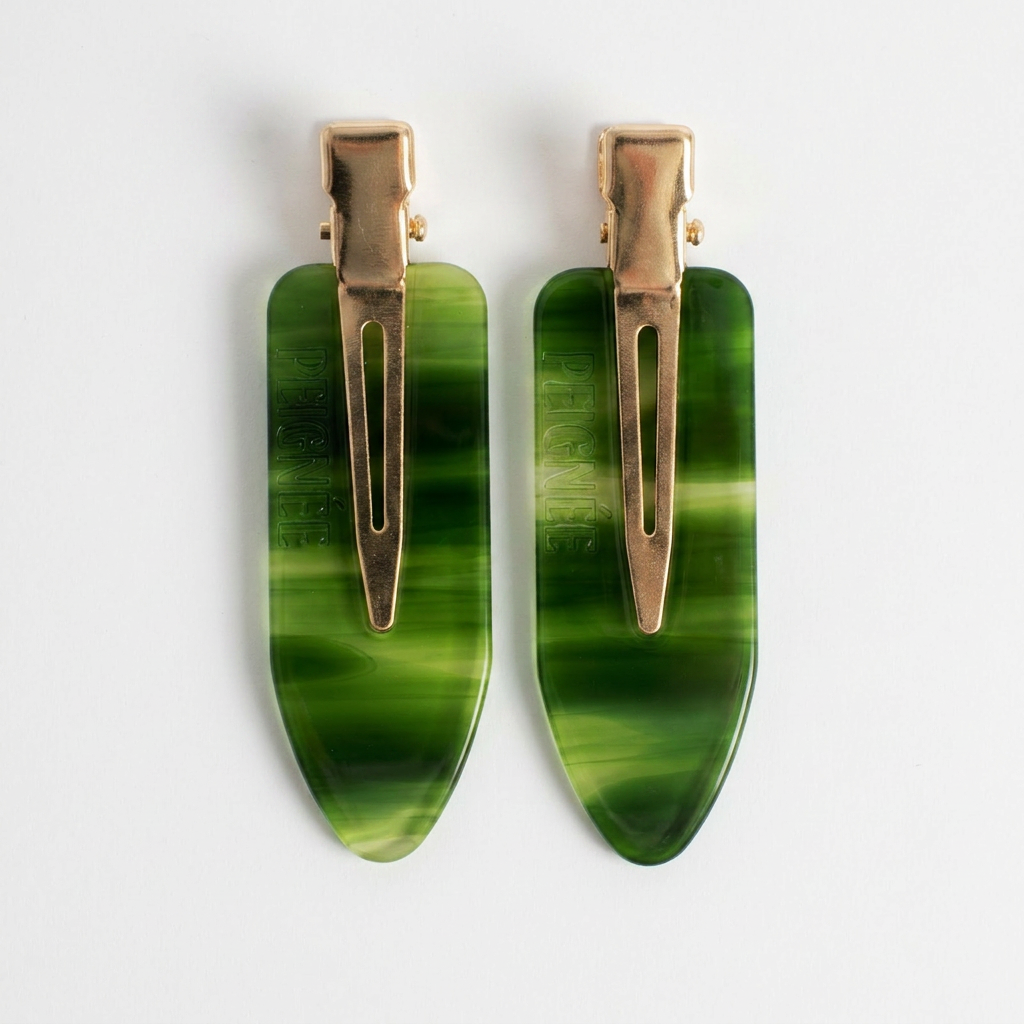 Peignee Paris Emerald Hair Clips, set of two, swirling emerald green acetate and gold-tone clips, flat lay on white.