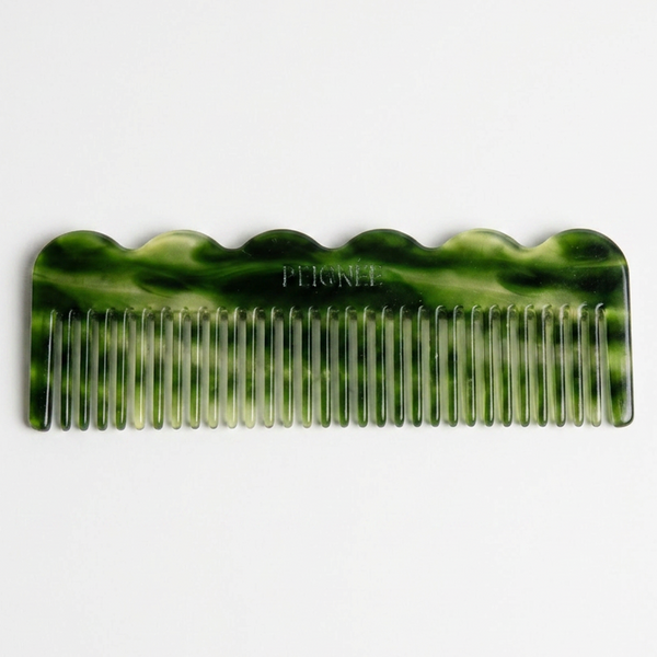 Peignee Paris Signature Wide-Tooth Wave Comb, emerald green marbled plant-based cellulose acetate, flat lay on white.