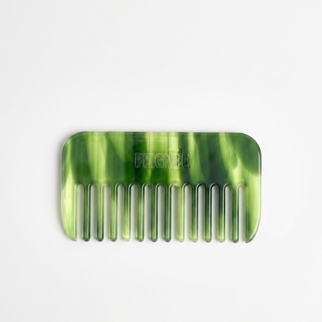 Peignee Paris Travel Wide-Tooth Wave Comb, emerald marbled plant-based cellulose acetate, front view on white.