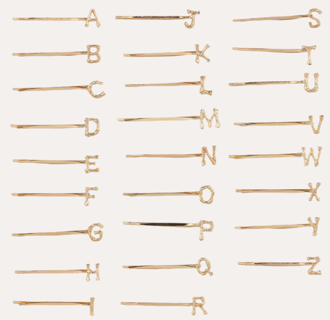 Peignée Alphabet Letter Hair Clip - Gold Plated. Gold hairpins with letters arranged in a grid on a white background