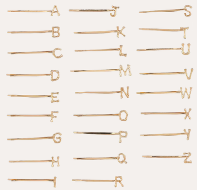 
                    
                      Peignée Alphabet Letter Hair Clip - Gold Plated. Gold hairpins with letters arranged in a grid on a white background
                    
                  