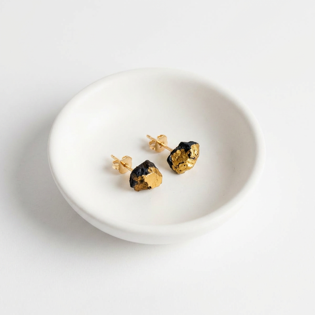 Reiko Yamamoto Studio Gold Ore Studs earrings, hand-formed black porcelain with 22k gold luster, flat lay pair in a white…