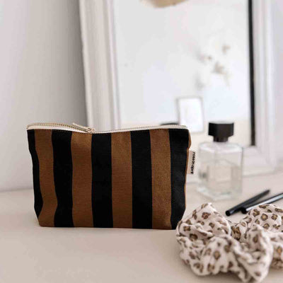 
                    
                      Sofia Pouch toiletry bag, cumin and black striped cotton canvas, with visible gold-tone zipper pull, angled front view.
                    
                  