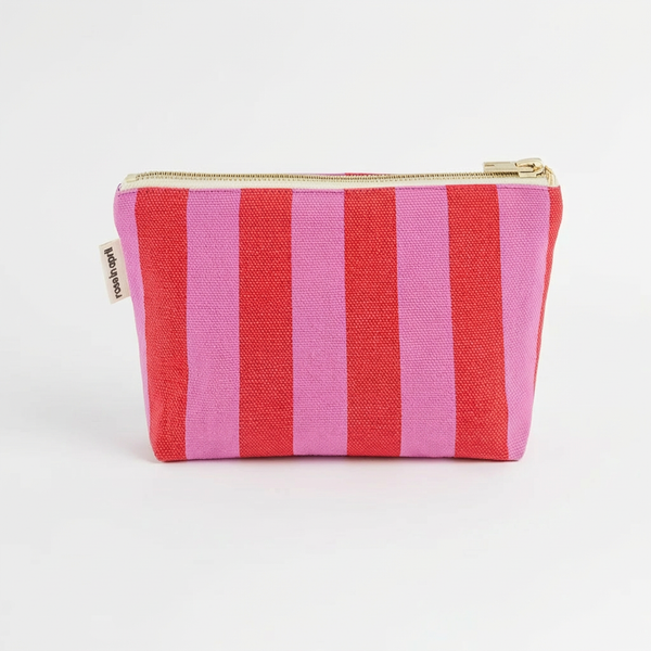 Rose in April Sofia Pouch - Orchid + Tomato studio product photo hanging from a wooden wall hook on a neutral off-white…