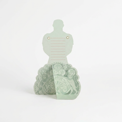 
                    
                      Strongman Die-Cut Card, light green cardstock standing upright, detailed pattern with lions on folded base, gold eyelets.
                    
                  