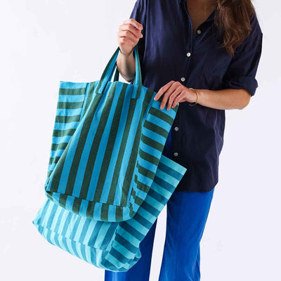 
                    
                      Elisabeth tote bag, turquoise and olive striped 100% cotton, held by person for scale and drape.
                    
                  