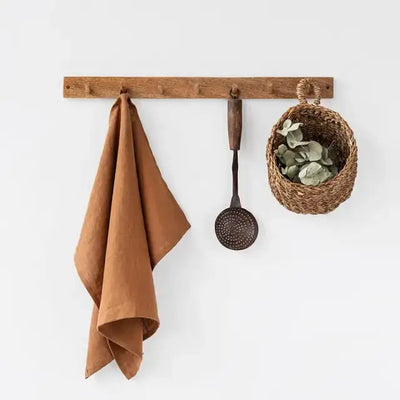 
                    
                      Premium linen tea towel in warm terracotta color, draped on a wooden wall hook.
                    
                  