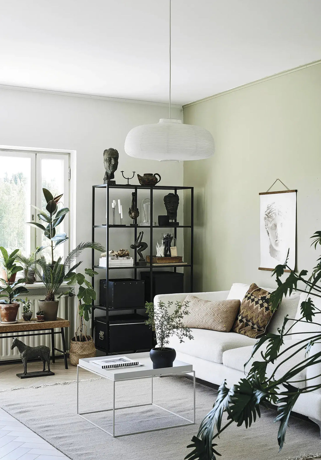 Cozy Publishing Green Home Book, open to white pages, resting on a minimalist white coffee table with a small potted plant,…