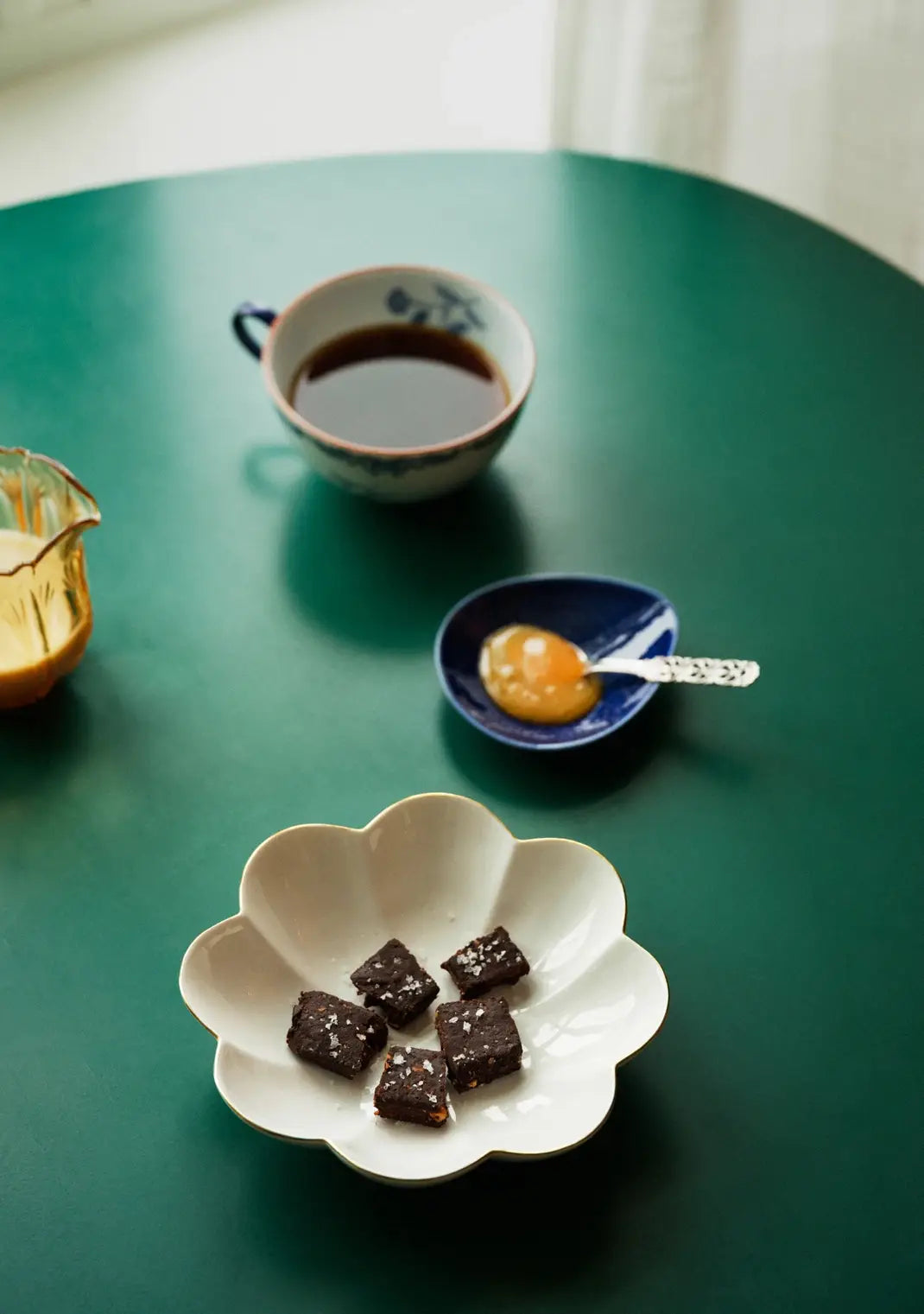 Norwegian Sea Salt Flakes, white crystals sprinkled on dark chocolate brownies, overhead view on a green table.