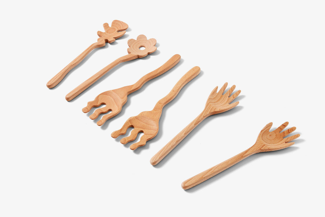 Areaware Serving Friends wooden serving utensils, full set of six unique hand and leaf-shaped beech wood pieces, flat lay.