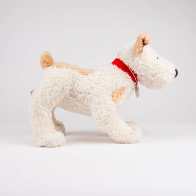 
                    
                      Eliot Stuffed Dog, cream plush with tan patches and red fabric collar, full side view, product tag visible.
                    
                  