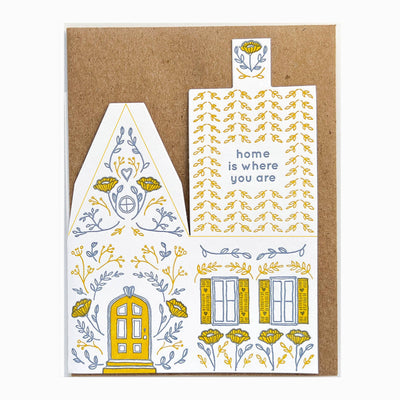 
                    
                      Home Is Where You Are 3D die-cut house card, open view revealing kraft base. Yellow & grey-blue letterpress art on white.
                    
                  