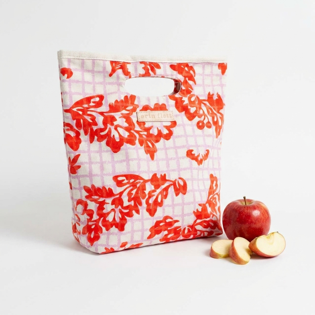 Erin Flett Betty Lunch Bag - (Anthro Orange + Lilac) studio product photo hanging from a wooden wall hook on a neutral…
