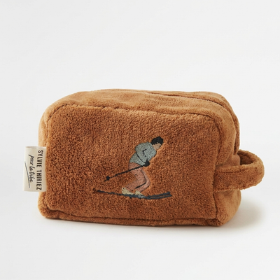 
                    
                      Sylvie Thiriez Après-Ski children's toiletry case, brown velvet fleece with embroidered skier, front view on white.
                    
                  