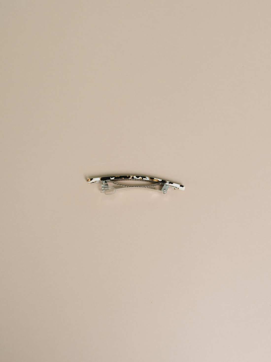NAT + NOOR Coco Cream hair clip, black and white tortoise acetate, detailed view of metal barrette clasp on light background.