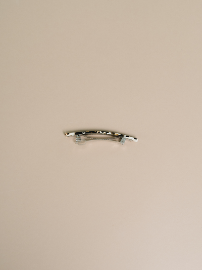 
                    
                      NAT + NOOR Coco Cream hair clip, black and white tortoise acetate, detailed view of metal barrette clasp on light background.
                    
                  