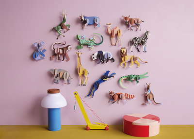 
                    
                      Kangaroo 3d build kit of recycled cardboard, brown, blue, and white, displayed on a pink wall among other colorful animal…
                    
                  