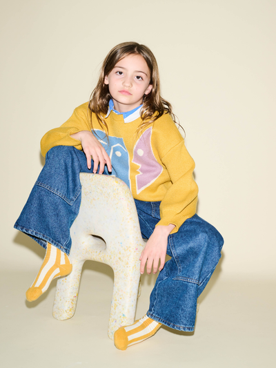 
                    
                      Kids Stripe Sock, yellow and white stripes, worn on a child's feet under wide-leg blue jeans.
                    
                  