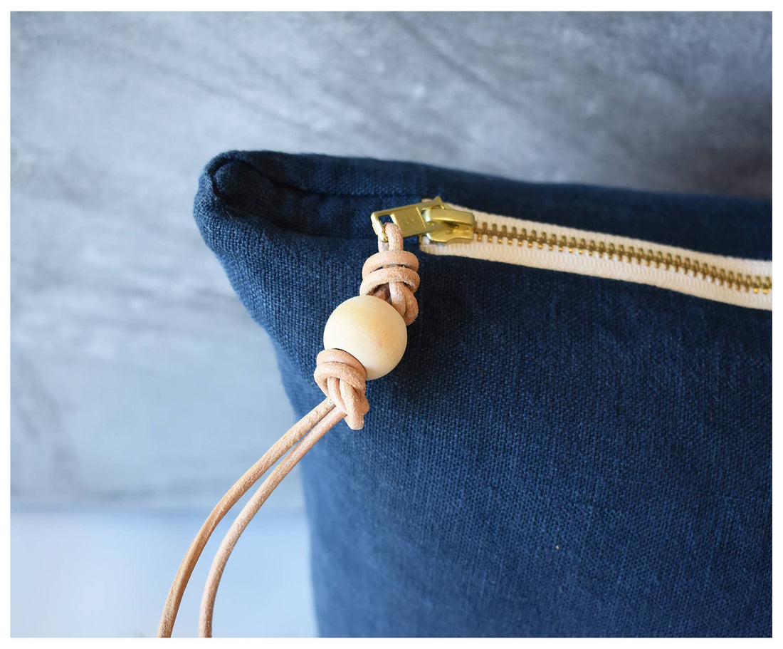Blue Washed Linen throw pillow, close-up of brass zipper detail with genuine leather pull and wooden bead.