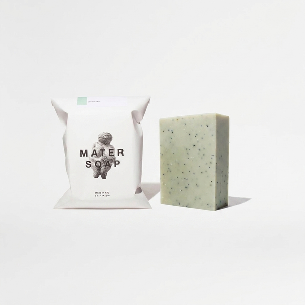 Mater Soap Basil Soap Bar, speckled light green bar and white packaging with logo, front view on white.