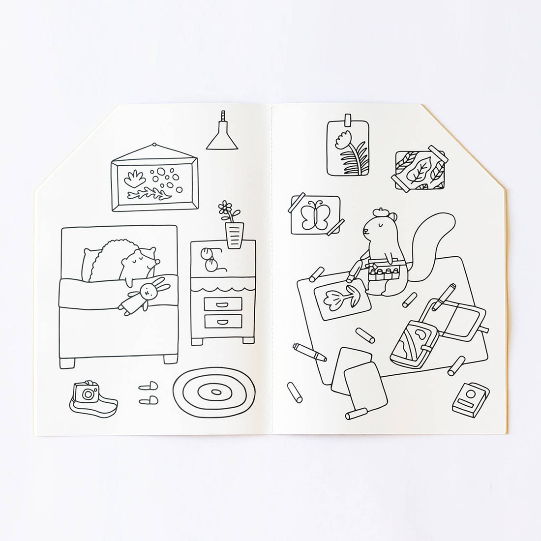 Jumbo House coloring book, open to interior pages with a sleeping creature and an artist squirrel. Black line art on white…