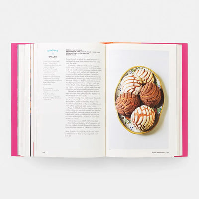 
                    
                      Mexico: The Cookbook open to Conchas recipe. Full-page photo displays white and chocolate conchas on a colorful plate.
                    
                  