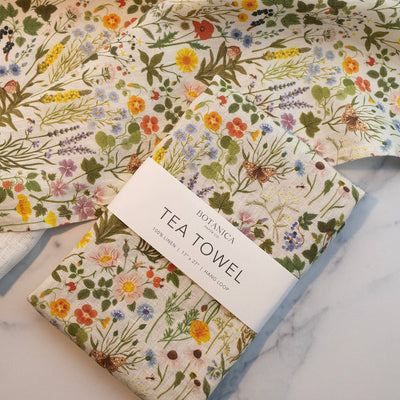 
                    
                      Botanica Paper Co. Botanist 100% linen tea towel, folded with branded band, vibrant multicolor wildflower pattern.
                    
                  