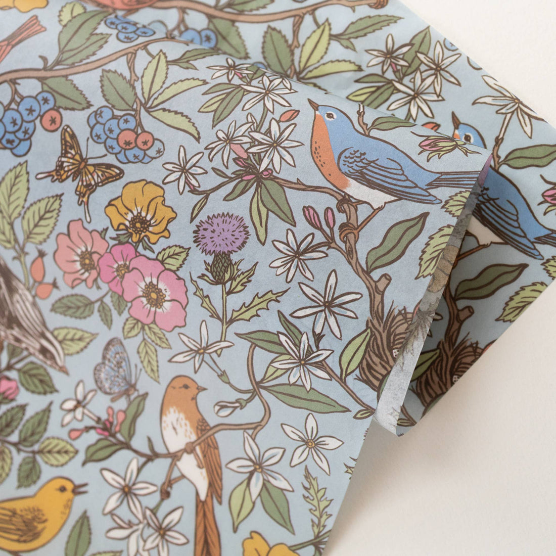 Botanica Paper Co. Songbirds tissue paper, light blue with colorful birds, flowers, berries, and butterflies, angled…