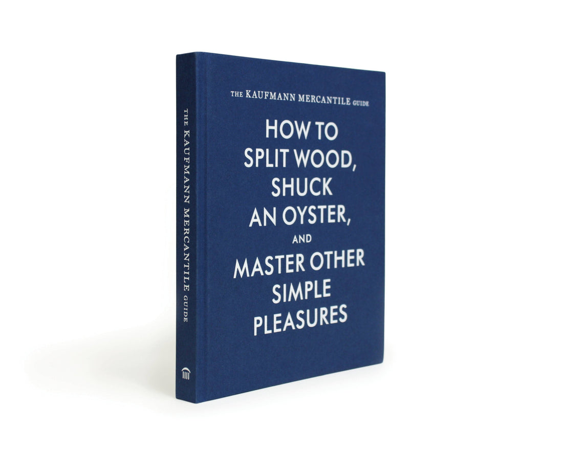 The Kaufmann Mercantile Guide print book, navy blue hardcover with white text, angled view showing the full front and spine.