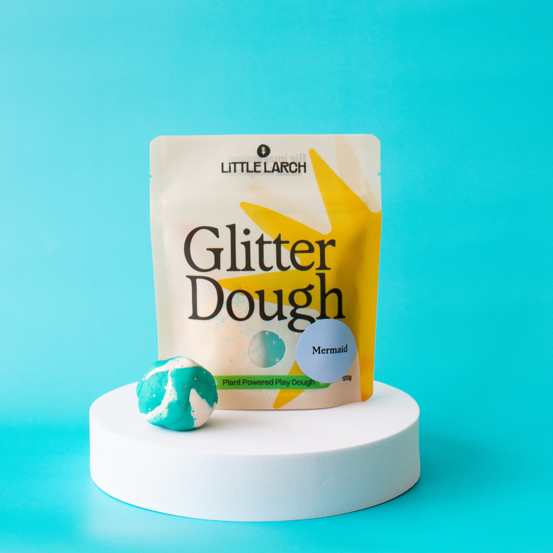 Little Larch Glitter Play Dough, Mermaid color pouch, with a teal and white marbled dough ball on a white pedestal.