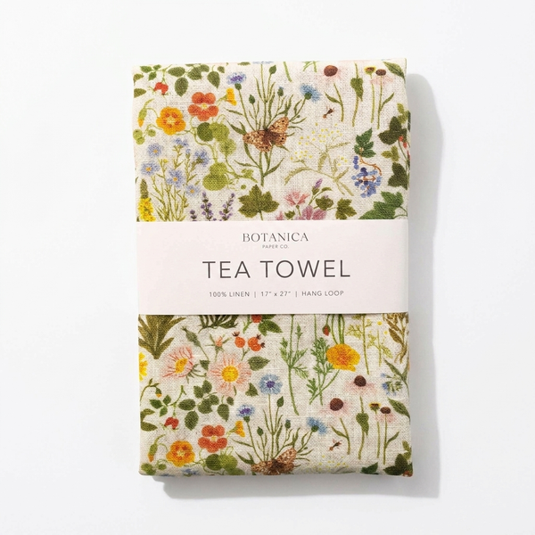 Botanica Paper Co. Botanist 100% linen tea towel, multi-color wildflower botanical print, folded with branded paper band,…