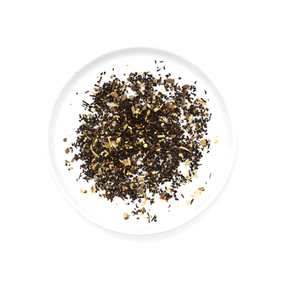 
                    
                      Gochujang Chai loose blend on white plate, an overhead flat lay showing dark tea leaves, light brown spices, and reddish…
                    
                  