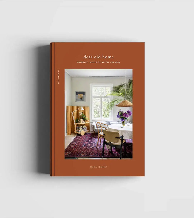 Cozy Publishing Dear Old Home print book, terracotta cover, front view with Nordic interior scene on cover, on white.