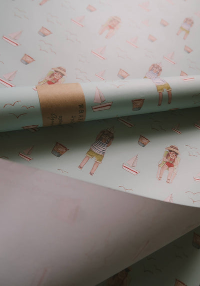 
                    
                      Summer Wrapping Paper, light mint green pattern of children, sailboats, and seagulls, rolled up with a brown kraft paper…
                    
                  