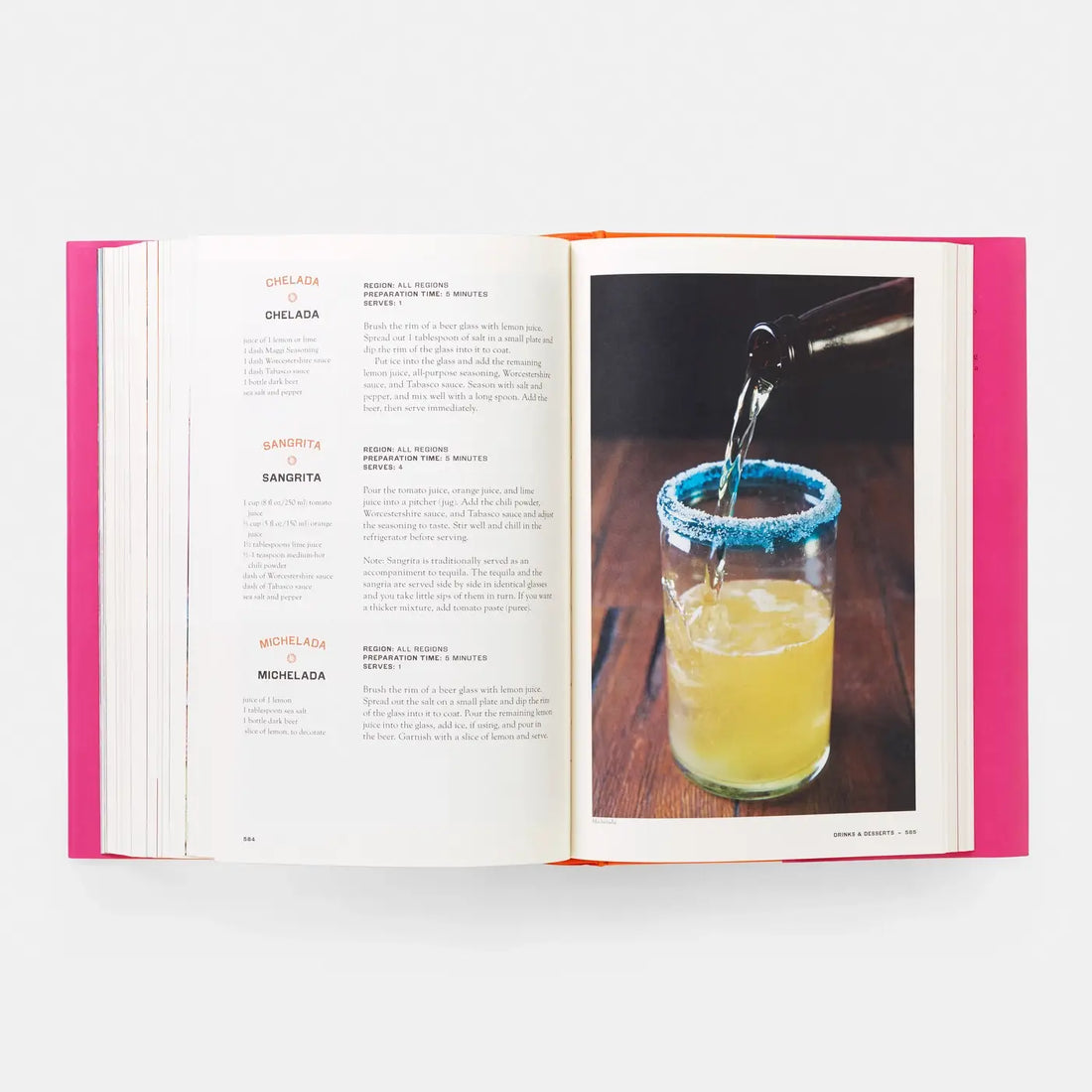 Mexico: The Cookbook, open to a Michelada recipe with a full-page photo of a drink being poured into a blue-rimmed glass,…