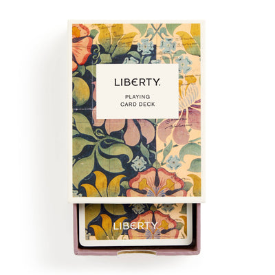 
                    
                      Liberty Archive playing card deck partially slid from its floral patterned slipcase, showing archival design notes and top…
                    
                  