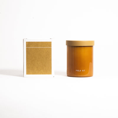 
                    
                      Field Kit Beekeeper Glass Candle, honey-amber glass jar with tan lid, shown side-by-side with its white and gold packaging…
                    
                  