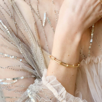 
                    
                      Adjustable Chunky Gold Paperclip Bracelet, 24K matte gold plating, on a light-toned wrist, close-up view.
                    
                  