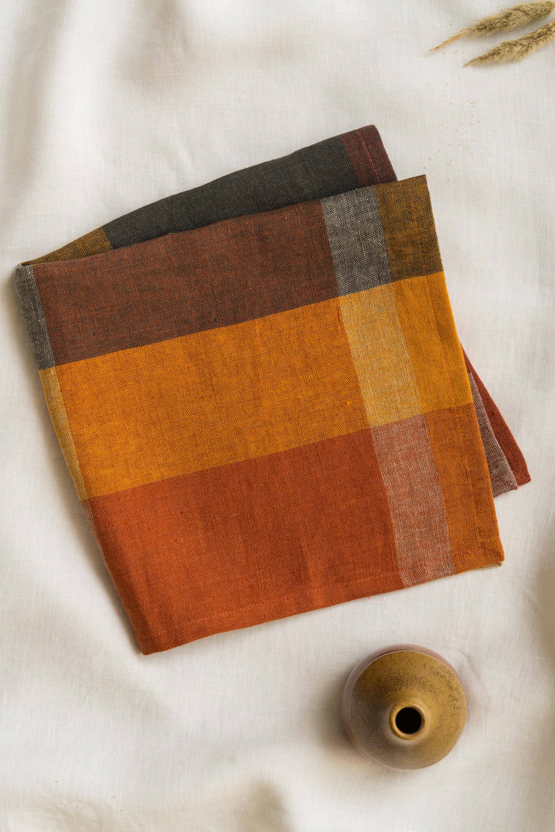 Live Linen Eugene Linen Napkin, Classic Checks. Two folded European linen napkins with brown, orange, mustard, charcoal…