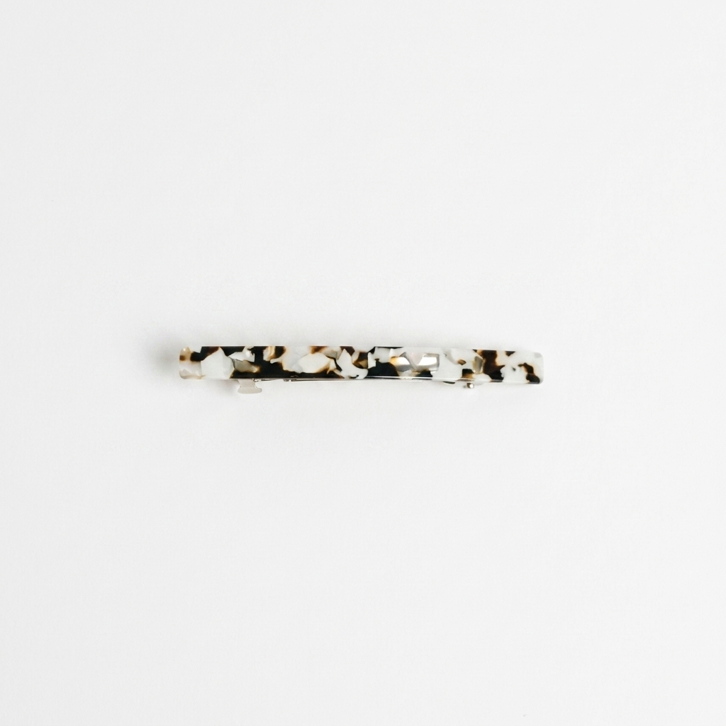 NAT + NOOR Coco Cream hair clip, white and brown tortoise cellulose acetate, flat lay front view.