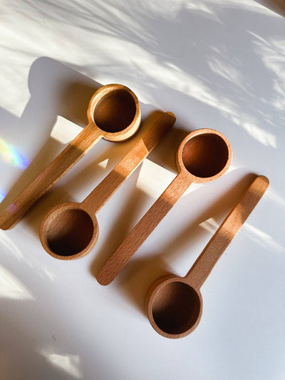 
                    
                      Wooden Tea Scoop, four unfinished beechwood scoops, flat lay, arranged diagonally with sunlight on white.
                    
                  