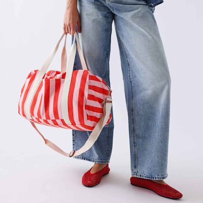 
                    
                      Raphael Weekend / Diaper Bag, tomato and candy pink striped cotton, held by person for scale.
                    
                  