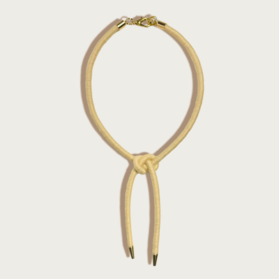 
                    
                      Sasha Shoelace Square Knot bolo tie, buttercream wool-wrapped cording, raw brass tips, gold-plated lobster clasp, front flat…
                    
                  