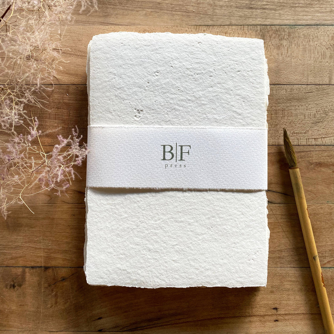 Bat Flower Press Ivory Handmade Paper Set, textured recycled cotton sheets, torn edges, branded belly band, flat lay.